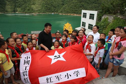 8月13日,全國(guó)紅軍小學(xué)建設(shè)工程理事會(huì)秘書(shū)長(zhǎng)方強(qiáng)(中)為學(xué)生們講述革命歷史。當(dāng)日,全國(guó)紅軍小學(xué)建設(shè)工程理事會(huì)考察組一行前往國(guó)家級(jí)貧困縣、鄂西山區(qū)長(zhǎng)陽(yáng)土家族自治縣資丘鎮(zhèn)考察當(dāng)?shù)亟逃l(fā)展情況,并決定在當(dāng)?shù)貫槔蠀^(qū)留守兒童援建全國(guó)首所“土家族紅軍小學(xué)”,這也將是全國(guó)第137所紅軍小學(xué)。長(zhǎng)陽(yáng)是湘鄂西革命根據(jù)地重要組成部分,賀龍?jiān)獛浽什烤胚M(jìn)長(zhǎng)陽(yáng),并在這里建立紅色政權(quán),發(fā)展革命武裝,開(kāi)展革命斗爭(zhēng),大批土家族兒女參加革命。新華社發(fā)(劉長(zhǎng)龍 攝)