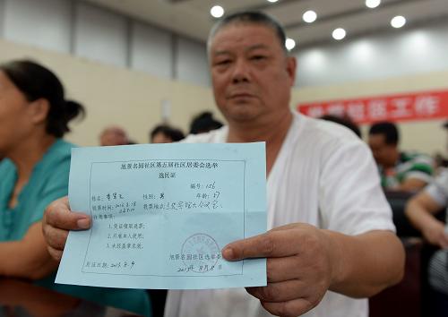 8月18日,一位選民在社區(qū)換屆選舉投票點(diǎn)展示自己的選民證。當(dāng)日,西安市蓮湖區(qū)西關(guān)街道旭景名園社區(qū)舉行第五次社區(qū)換屆選舉工作。此次選舉采取無候選人直接選舉的方式,這也是西安市首次進(jìn)行社區(qū)居民委員會(huì)無候選人直選。最終299名選民為自己的社區(qū)居民委員會(huì)選舉出一名主任、兩名副主任和四名委員,選舉結(jié)果將在公示七日后正式生效。新華社記者 李一博 攝