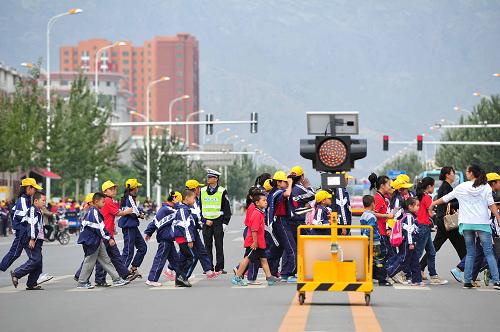 9月4日,在寧夏回族自治區(qū)石嘴山市第十九小學外,小學生在交警的指揮下過馬路。新華社記者 彭昭之 攝