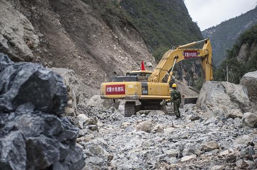 9月5日,武警水電部隊挖掘機在清理通往巴拉格宗景區(qū)道路上的最后一個塌方點。新華社記者 張可任 攝