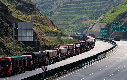 由于保德縣城道路堵車(chē),從忻保高速(忻州-保德)保德出口駛出的運(yùn)煤車(chē)遭到限行,從府谷石馬川進(jìn)入保德的車(chē)輛也遭遇堵車(chē),綿延10公里(9月5日攝)。陜西省榆林市府谷縣近期煤炭外運(yùn)遭遇“腸梗阻”。運(yùn)煤車(chē)輛不僅無(wú)法通過(guò)新建的高速公路,原有的兩條公路中一條也因維修而封堵。在陜西與山西交界處,運(yùn)煤車(chē)輛排起長(zhǎng)龍,有時(shí)會(huì)綿延達(dá)數(shù)十公里。據(jù)初步估算,從7月份至今,直接經(jīng)濟(jì)損失已達(dá)5億元。據(jù)府谷縣煤炭運(yùn)輸管理部門(mén)負(fù)責(zé)人介紹,2012年12月忻保高速開(kāi)通后,由于種種原因,煤焦車(chē)輛一直沒(méi)有放行。車(chē)輛只能選擇神(池)保(德)公路、禹保線(xiàn)進(jìn)入山西境內(nèi),由于公路承載能力有限,多年來(lái)的交通擁堵問(wèn)題沒(méi)有得到緩解。特別是今年7月份以來(lái),神保公路實(shí)施維修,預(yù)計(jì)年底才能改造完畢,原運(yùn)煤道路封堵,交通擁堵更加嚴(yán)重。而部分煤焦車(chē)輛就近辦理山西省煤焦入境手續(xù)后,又折返選擇高速公路通行,導(dǎo)致道路雙向堵塞。一些煤車(chē)司機(jī)和當(dāng)?shù)毓ぷ魅藛T表示,希望相關(guān)方面能夠考慮擁堵造成的問(wèn)題,盡快在高速公路入口或合適的地點(diǎn)建設(shè)煤焦檢測(cè)站,為過(guò)境車(chē)輛辦理入境手續(xù),使煤車(chē)能夠順利通行,減少因此造成的經(jīng)濟(jì)損失。新華社記者 劉瀟 攝