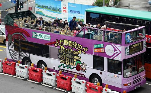 一些內(nèi)地游客在香港中環(huán)乘坐觀光巴士游覽(1月27日攝)。新華社記者 李鵬 攝
