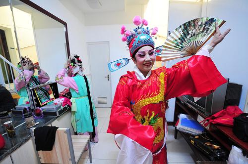 10月4日,在寧夏回族自治區(qū)銀川市興慶區(qū)自強社區(qū)內(nèi),秦韻樂藝術(shù)團的成員在后臺記戲詞準備登臺演出。新華社記者 彭昭之 攝
