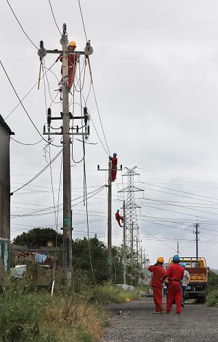 10月7日,椒江區(qū)供電公司的工作人員在搶修位于椒江北岸的10千伏章礁442線,保障2家企業(yè)和100多戶居民的用電。新華社發(fā)(郭一均 攝)