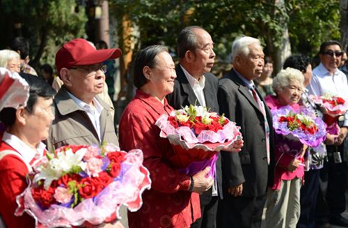 10月13日,“金婚”老人們手捧鮮花參加慶?;顒?dòng)。新華社記者 朱崢 攝