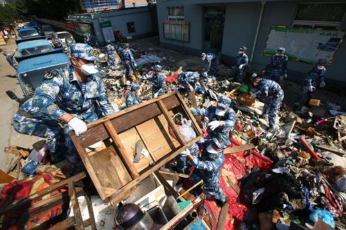 10月14日,東海艦隊某電子對抗團官兵在余姚新城市社區(qū)清理洪水帶來的垃圾。新華社發(fā)(代宗鋒 攝)