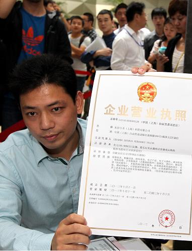 10月14日,一位企業(yè)代表在上海自貿(mào)區(qū)展示領取到的外國法人獨資企業(yè)營業(yè)執(zhí)照。10月14日,上海自貿(mào)區(qū)首批通過“一窗口辦理”方式申請入駐的企業(yè)開始領取營業(yè)執(zhí)照。10月8日,上海自由貿(mào)易試驗區(qū)開始在綜合服務大廳受理入駐企業(yè)登記注冊。申請企業(yè)可在同一個窗口完成從遞交材料到領取執(zhí)照的全部過程,審批時間也從29天縮短到4個工作日。新華社記者 陳飛 攝