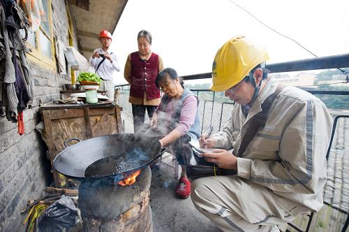 10月15日,國網(wǎng)重慶永川供電公司的一名電力職工在“棄管小區(qū)”之一的永川火車站南路48號的老舊居民樓內(nèi)了解收集當(dāng)?shù)刈粼陔娏υO(shè)施設(shè)備改造的需求。新華社記者 劉潺 攝