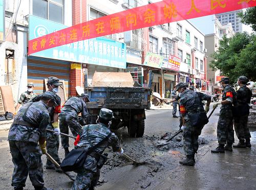 第1集團(tuán)軍某炮兵團(tuán)官兵在余姚大黃橋南路的江南新村社區(qū)清除淤泥垃圾(10月14日攝)。新華社發(fā)(郭維虎 攝)