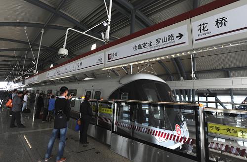 10月16日,乘客在昆山花橋站站臺候車。當日,上海軌道交通11號線北段延伸工程花橋段(上海安亭站至昆山花橋站)開通試運營,從江蘇省昆山市搭乘地鐵直達上海市區(qū)成為現實。這是我國首條跨省市地鐵線路。新開通的上海軌道交通11號線北段延伸段工程花橋段(安亭站至花橋站)線路總投資18.5億元,為全長6公里的高架線路。該段東起上海安亭站,向西設兆豐路、光明路、花橋3站,均在江蘇省昆山境內。最大站間距3.3公里,最小站間距1.1公里,平均站間距1.9公里。花橋段開通試運營后,上海軌道交通11號線運營總里程達到72公里。而從江蘇省境內的花橋站出發(fā),約1個小時即可進入上海市中心,進行軌道交通網絡換乘,這將有利于蘇、滬兩地居民的出行與通勤。新華社記者 劉巍巍 攝