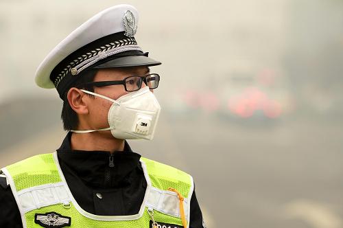 10月29日,在濟南市濼源大街執(zhí)勤的交警戴著口罩疏導(dǎo)交通。當(dāng)日,山東省濟南市遭遇嚴(yán)重霧霾天氣。濟南市環(huán)境空氣質(zhì)量監(jiān)測顯示,市區(qū)15個監(jiān)測點全部為重度污染或嚴(yán)重污染。受嚴(yán)重霧霾天氣影響,山東境內(nèi)榮烏高速、長深高速局部路段道路封閉。新華社記者 郭緒雷 攝