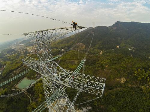 10月30日,浙江省送變電公司的施工人員在60多米高的輸電鐵塔頂部進(jìn)行最后的附件的安裝。新華社記者 徐昱 攝