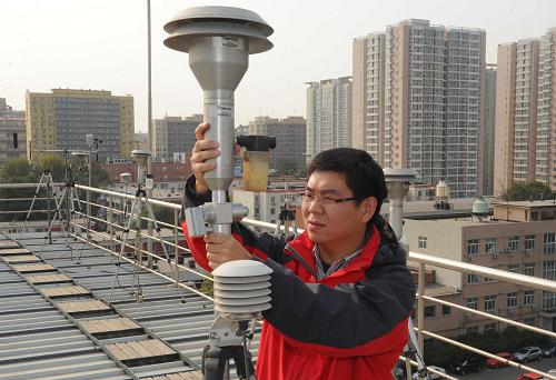 10月30日,北京市環(huán)境保護(hù)監(jiān)測(cè)中心工作人員對(duì)PM2.5監(jiān)測(cè)設(shè)備進(jìn)行檢查。新華社記者 公磊 攝