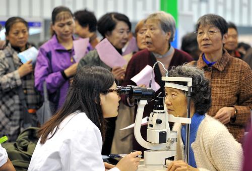 11月1日,一家參展眼科醫(yī)院的醫(yī)務(wù)人員在為老人免費(fèi)篩查眼疾。新華社發(fā)