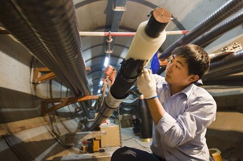11月4日,在江蘇無錫220千伏蠡湖輸變電工程工地上,電力職工在安裝制作電纜接頭。新華社發(fā)(潘正光 攝)