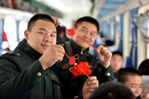 11月25日,在重慶菜園壩火車(chē)站開(kāi)往云南的列車(chē)上,武警重慶總隊(duì)六支隊(duì)退伍老兵展示女兵戰(zhàn)友自己編制送給他們的“中國(guó)結(jié)”。當(dāng)日,武警重慶總隊(duì)在菜園壩火車(chē)站舉行退役士兵歡送儀式,送別2500余名退役老兵返鄉(xiāng)。新華社發(fā)(張春華 攝)