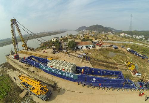 11月26日,浙江省送變電公司的工作人員在碼頭上檢查巨型運輸車上的換流變壓器,為即將開始的陸地運輸做準備。新華社記者 徐昱 攝