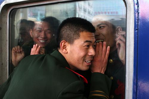 11月25日,駐大連武警某部退伍老兵登車后,與送行的戰(zhàn)士隔著車窗深情告別。沈陽鐵路局大連站把退伍老兵運輸列入車站重點工作,專人負(fù)責(zé)引導(dǎo)老兵檢票進站,確保登乘安全。新華社發(fā)(郭偉 攝)