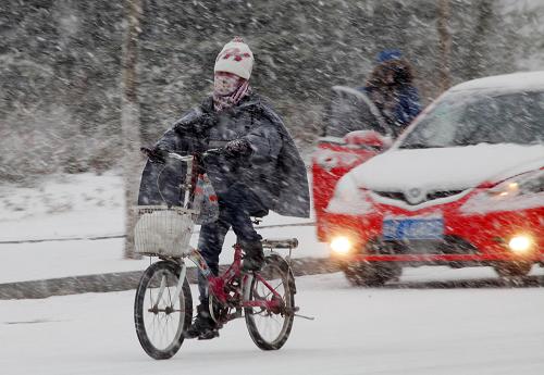 11月28日,在威海市鳳林路,一名騎車人頂著風(fēng)雪前行。新華社發(fā)(于啟波 攝)