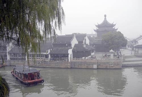 12月7日,游船行駛在霧霾籠罩的蘇州護城河上。新華社發(fā)(王建康 攝)