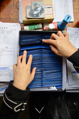 12月11日,工作人員在湖南省委大院內(nèi)開設(shè)的流動服務(wù)點為公車辦理換牌手續(xù)。新華社記者 白禹 攝