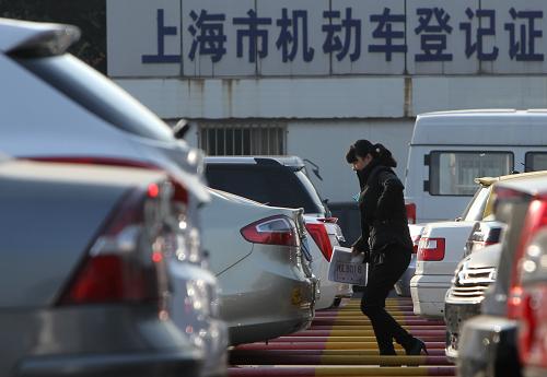 12月11日,一位辦理上牌手續(xù)的市民從上海市交警總隊車輛管理所三分所的停車場經(jīng)過。上海市機動車額度管理辦公室近日表示,上海將調(diào)整當前車牌拍賣規(guī)則,2014年起試行一次性公布機動車額度年度投放總量和“警示價”措施,同時,實施個人、單位機動車額度分場投標拍賣。據(jù)了解,上海確定了2014年機動車額度投放總量保持在10萬張左右,每月額度投放量保持基本均等,并決定選擇2013年最低“警示價”72600元作為年度“警示價”。競買人首次出價階段出價高于“警示價”,系統(tǒng)將不予接受。新華社記者 裴鑫 攝
