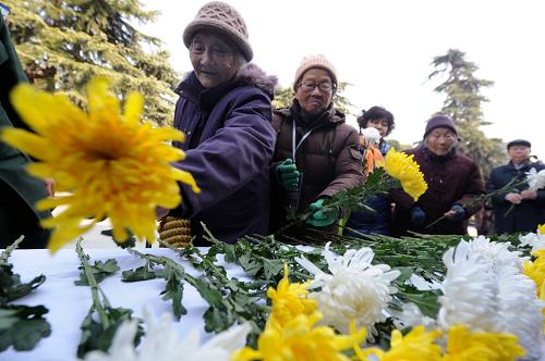12月13日,南京大屠殺幸存者和遇難者家屬代表向30萬遇難者獻花。新華社記者 韓瑜慶 攝