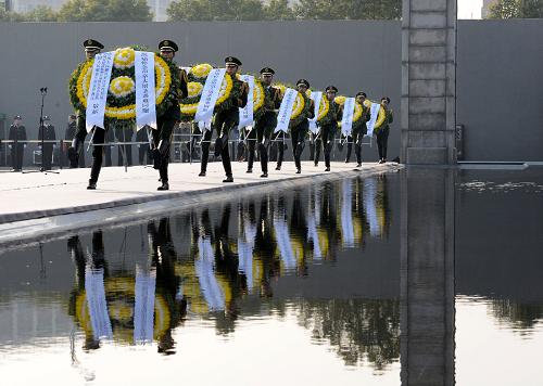 12月13日,武警戰(zhàn)士向30萬(wàn)遇難同胞敬獻(xiàn)花圈。新華社記者 孫參 攝