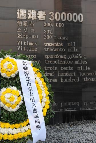12月13日,南京大屠殺遇難同胞紀(jì)念館內(nèi)的悼念墻前擺放著花圈。新華社記者 孫參 攝
