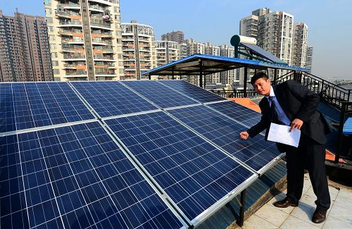 12月13日,高松在自家屋頂查看太陽能電板。日前,在與國家電網(wǎng)簽訂臨時(shí)結(jié)算協(xié)議后,湖北省居民光伏發(fā)電第一人高松收到了武漢供電公司支付的第一筆812.6元的上網(wǎng)電費(fèi)。今年5月22日,武漢市民高松在自家屋頂建造了家庭光伏電站,并入國家電網(wǎng),日常發(fā)電除自家使用外,剩余部分以每度電0.478元的價(jià)格賣給國家電網(wǎng)。從5月22日并網(wǎng)到11月22日,高松家的個(gè)人電站累計(jì)發(fā)電2700度,上網(wǎng)賣電1700度獲得812.6元,自用電量1000度,相當(dāng)于節(jié)省電費(fèi)623元。之前因?yàn)榫用癫痪邆溟_具增值稅發(fā)票條件的原因,高松一直沒法兌現(xiàn)賣電收入。近日,國家電網(wǎng)湖北省電力公司和武漢供電公司決定,在國家出臺(tái)具體政策前,按照國家規(guī)定的價(jià)格標(biāo)準(zhǔn),與符合條件的居民分布式光伏發(fā)電項(xiàng)目業(yè)主,通過簽訂臨時(shí)結(jié)算協(xié)議的方式,先期進(jìn)行預(yù)結(jié)算,支付給高松812.6元的賣電款,待條件齊備后,按“多退少補(bǔ)”的原則進(jìn)行正式結(jié)算和辦理財(cái)務(wù)手續(xù)。新華社記者 程敏攝