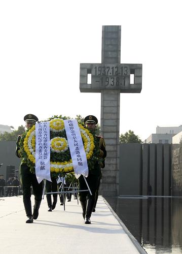 12月13日,武警戰(zhàn)士向30萬遇難同胞敬獻(xiàn)花圈。新華社發(fā)