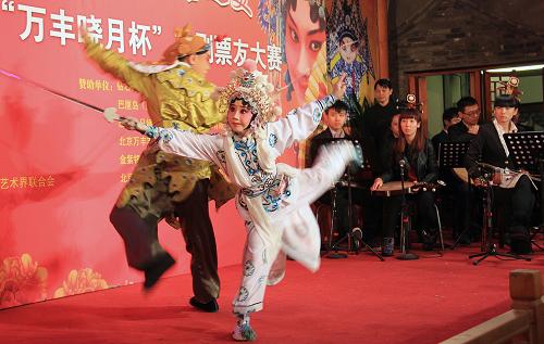 12月21日,9歲的京劇小票友布尼王茜表演京劇《盜仙草》選段。當(dāng)日,匯聚北京25家戲迷社、百余名票友的“萬豐曉月”杯京劇票友大賽決賽在北京盧溝橋鄉(xiāng)萬豐大戲樓舉行。這次京劇大賽由盧溝橋鄉(xiāng)小井村承辦。“梨園之村”小井村近年來發(fā)揮傳統(tǒng)優(yōu)勢,弘揚(yáng)戲曲文化,創(chuàng)辦的隆韻戲迷社吸引了北京城區(qū)眾多戲迷朋友加盟。新華社發(fā)(李建 攝)
