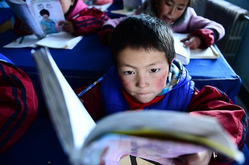 12月24日,在青海省海北藏族自治州剛察縣沙柳河鎮(zhèn)寄宿制小學,二年級二班學生俄合加在課堂上朗誦課文。新華社記者 張宏祥 攝