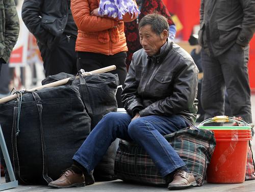 1月18日,64歲的董先生在上?;疖囌就獾却6壬呛幽像v馬店人,在上海一建筑工地打工。因?yàn)閾?dān)心誤了火車,他當(dāng)天下午1點(diǎn)就已經(jīng)到了火車站,需要在火車站外等上近10個(gè)小時(shí)。新華社發(fā)(丁汀 攝)