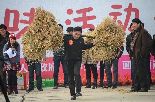 1月18日,在浙江省長(zhǎng)興縣畫(huà)溪街道,草莓合作社的農(nóng)民和游客參加趣味農(nóng)事活動(dòng)“挑稻草”。新華社記者 徐昱 攝