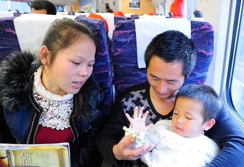 1月24日,齊平華、章元妹(左)夫婦和他們的大兒子齊志杰在D6502次新福州人免費(fèi)返鄉(xiāng)動(dòng)車(chē)專(zhuān)列上。當(dāng)日,中鐵四局福州京臺(tái)高速JTA6合同段工人齊平華、章元妹夫婦帶著大兒子一同乘坐福州開(kāi)往南昌的D6502次“新福州人免費(fèi)返鄉(xiāng)動(dòng)車(chē)專(zhuān)列”,踏上回家過(guò)年的旅程。下午,他們回到了老家江西省進(jìn)賢縣泉嶺鄉(xiāng)大塘村,和家人在小年這天團(tuán)聚。“回家過(guò)年”是齊平華夫婦這樣外出打工者過(guò)年時(shí)的祈盼。齊平華說(shuō):“去年回家還要等加增的臨客車(chē),今年能坐上新福州人免費(fèi)返鄉(xiāng)動(dòng)車(chē)專(zhuān)列,又快又方便。”新華社記者 林善傳 攝