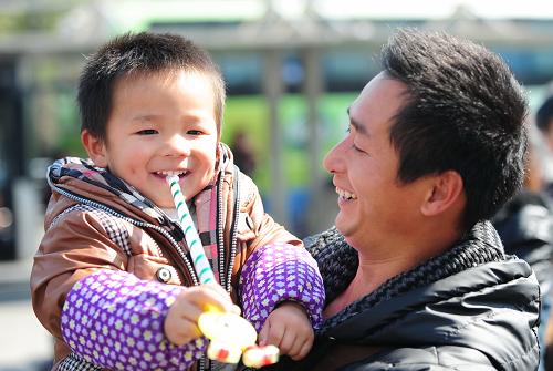 1月24日,到達(dá)南昌火車(chē)站,齊平華的大兒子齊志杰高興地玩著剛買(mǎi)的玩具。新華社記者 林善傳 攝