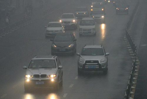 1月31日,在鄭州市區(qū)的道路上,車輛在霧中行駛。 新華社記者 王頌 攝