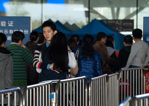 2月5日,一對(duì)情侶在深圳北站進(jìn)站口離別時(shí)擁抱。新華社記者 毛思倩 攝