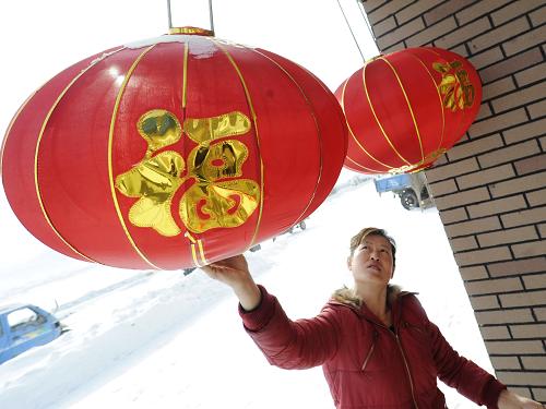 吉林省樺甸市二道甸子鎮(zhèn)暖木村農(nóng)民在門前懸掛紅燈籠(1月20日攝) 。新華社記者 林宏 攝