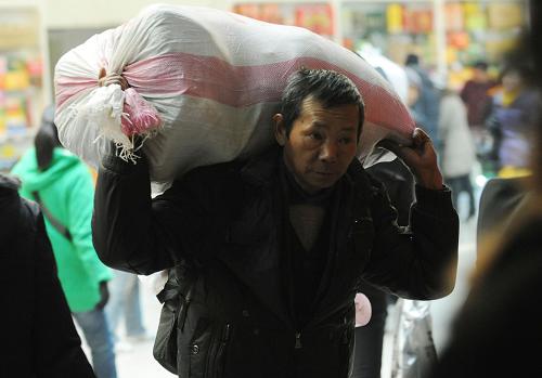 1月26日,一名背著大包的農(nóng)民工在鄭州火車站準(zhǔn)備乘車回家。新華社記者 趙鵬 攝