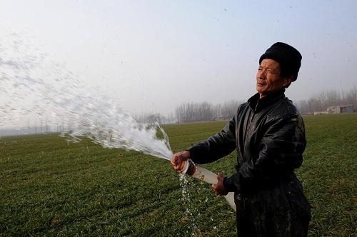 2月6日,河南省上蔡縣蔡溝鄉(xiāng)曹莊村農(nóng)民朱玉興在田間澆水。新華社記者朱祥攝