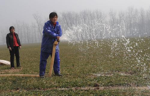 2月6日,河南省淮陽縣許灣鄉(xiāng)何莊農(nóng)民雷鳳梅(右)和家人在麥田內(nèi)澆水。新春伊始,天氣轉(zhuǎn)暖,豫東農(nóng)村田間地頭多處可見繁忙的抗旱景象。河南省連續(xù)多日無雨,各地旱情嚴(yán)重,小麥?zhǔn)芎得娣e近3000萬畝。新華社記者趙鵬攝