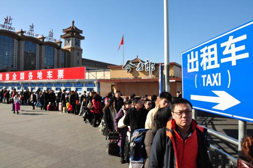 2月6日,返程旅客在北京站前排隊(duì)等候出租車(chē)。新華社發(fā)(樊甲山 攝)