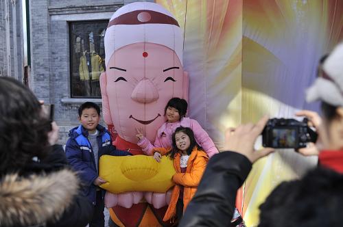 2月17日,幾名小朋友在北京前門大街的一處充氣人偶前留影。新華社記者 魯鵬 攝