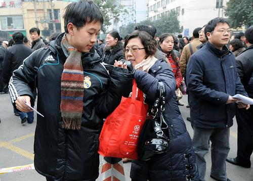 這是2010年1月16日,在位于南京廣播電視大學的清華大學、南京大學、中國科技大學、西安交通大學、上海交通大學5所高校自主招生聯(lián)考考點外,一位家長在為即將參加考試的孩子“打點行裝”。新華社記者 孫參 攝