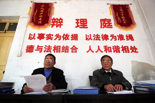 信豐縣古陂鎮(zhèn)“說理庭”兩名成員在對一起土地流轉(zhuǎn)糾紛進(jìn)行調(diào)解(3月5日攝)。新華社記者 周科 攝