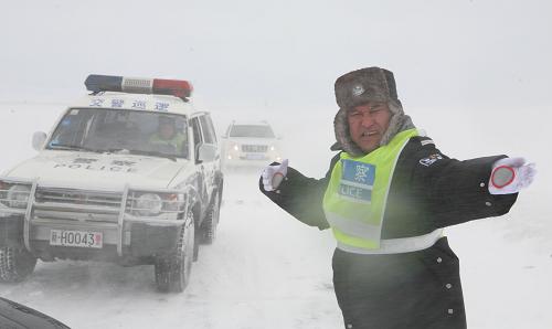 3月16日,新疆阿勒泰市交警大隊(duì)干警頂風(fēng)冒雪疏導(dǎo)被困車輛。新華社發(fā)(葉爾江 攝)