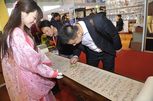 3月16日,一名觀眾在用放大鏡欣賞《懷素自敘帖》高仿精品。新華社記者 魯鵬 攝