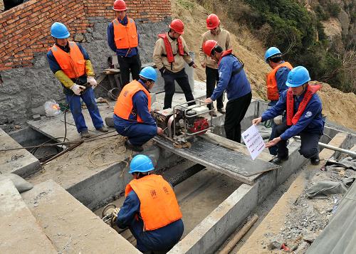 3月16日,工人正在將海上引來的電纜鋪設(shè)上島。新華社記者 徐昱 攝